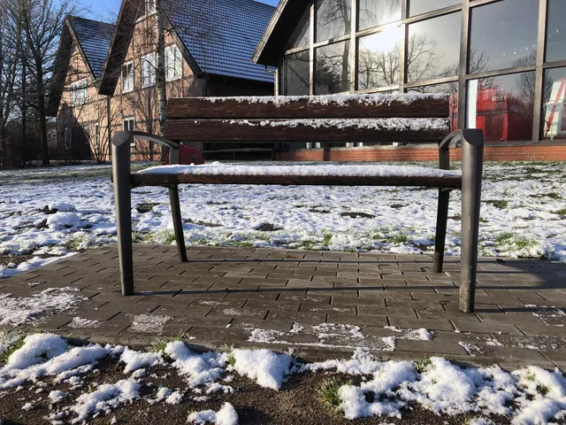 Parkbank im Schnee bei Sonnenschein